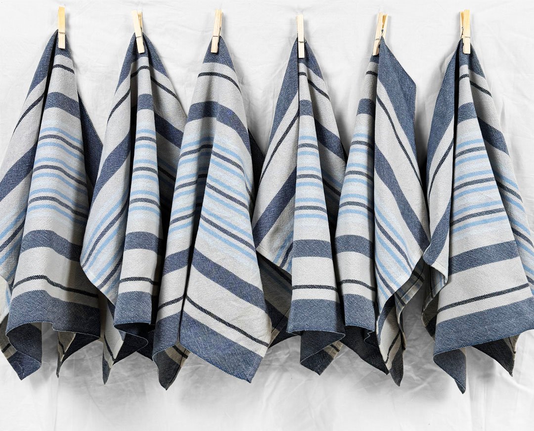 a line of hanging grey and blue towels