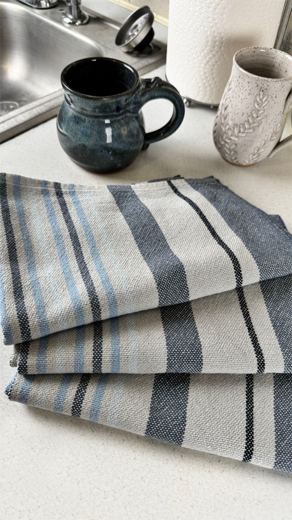 three grey and blue towels on a counter