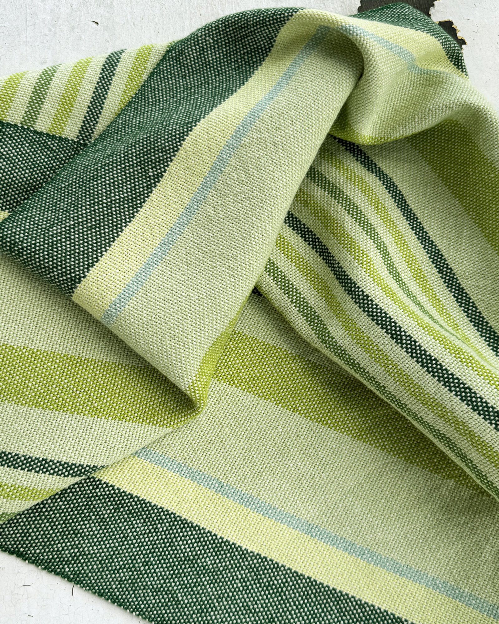 close up of a folded green striped towel