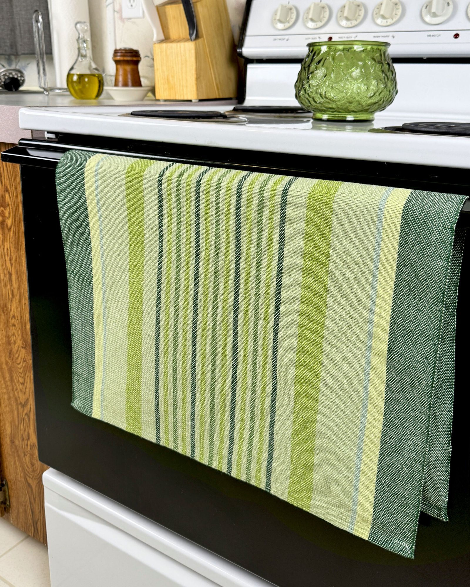 green striped towel hanging on an oven door handle